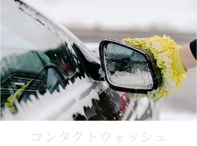 洗車用ミットで車のボディを優しく洗浄している様子