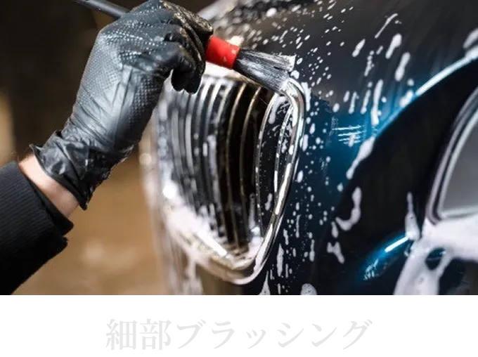 ブラシを使って車の細部を丁寧に洗浄している様子