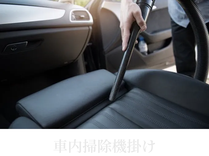 車内清掃でシートや足元に掃除機をかけている様子