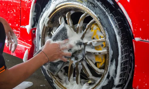 専用スポンジで車のホイールを洗浄している様子