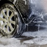 泡を使って車のボディとホイールを洗車している様子